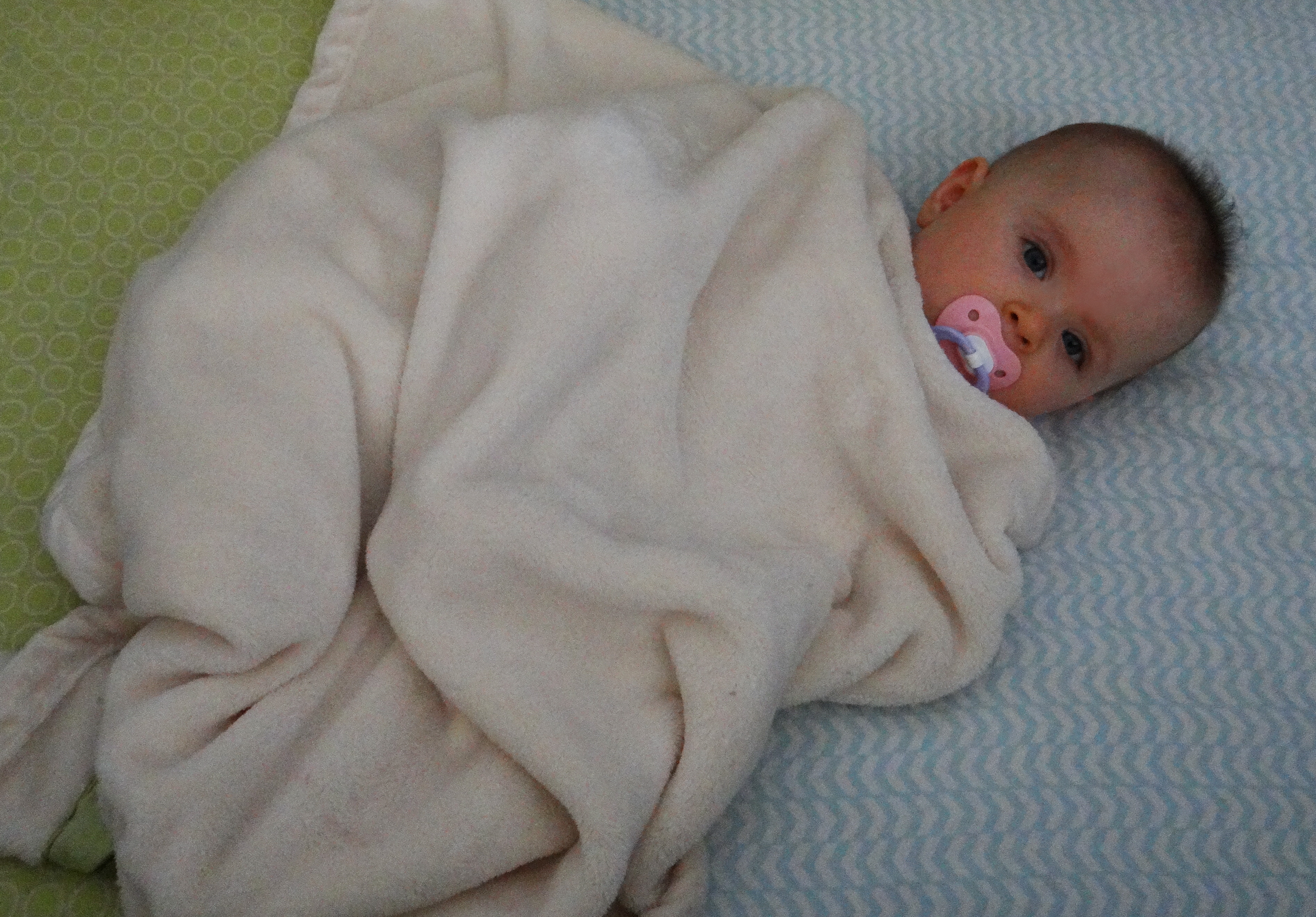 Baby bundled in a fuzzy blanket in a crib