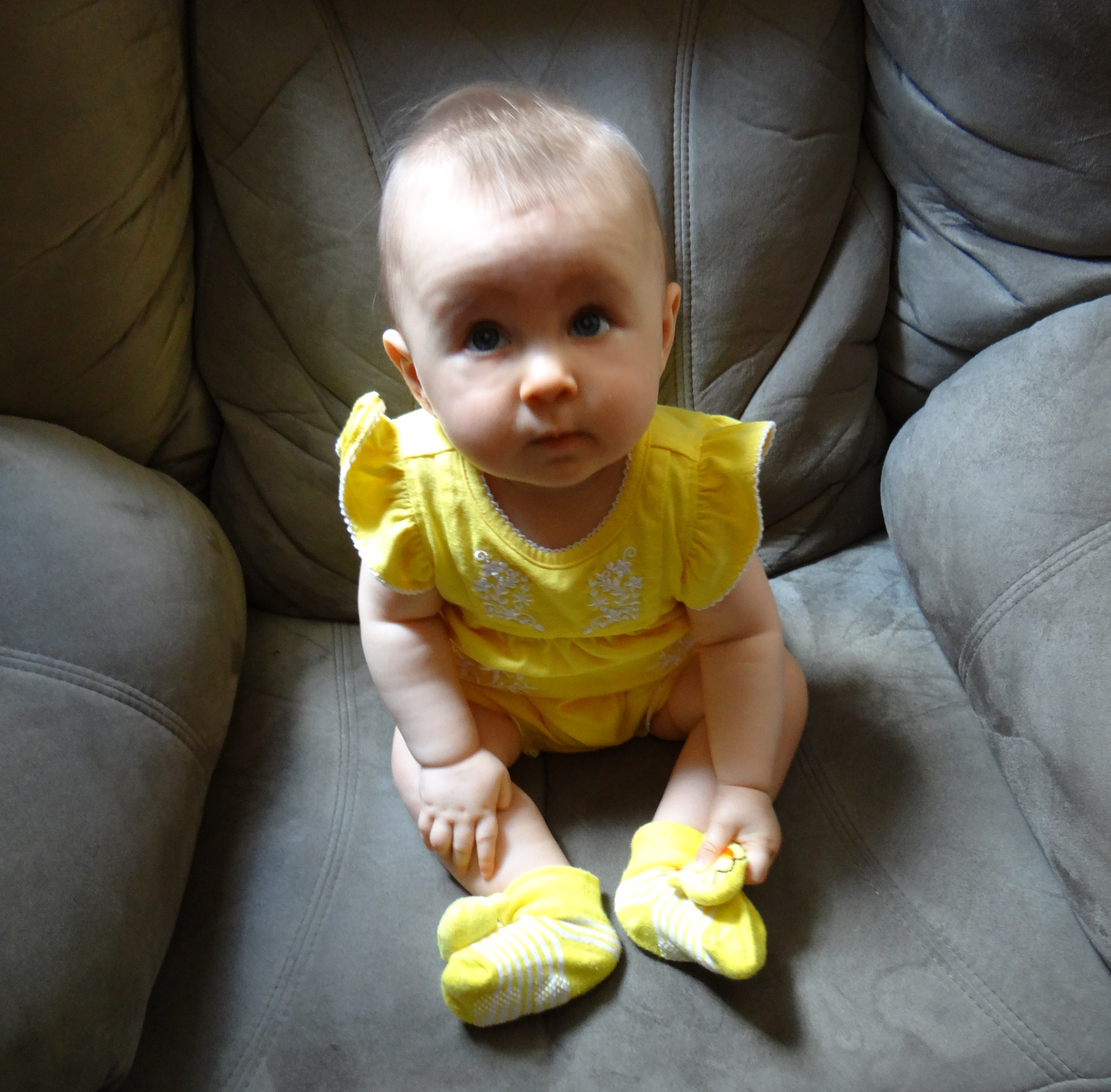 Adorable baby girl in a yellow outfit.