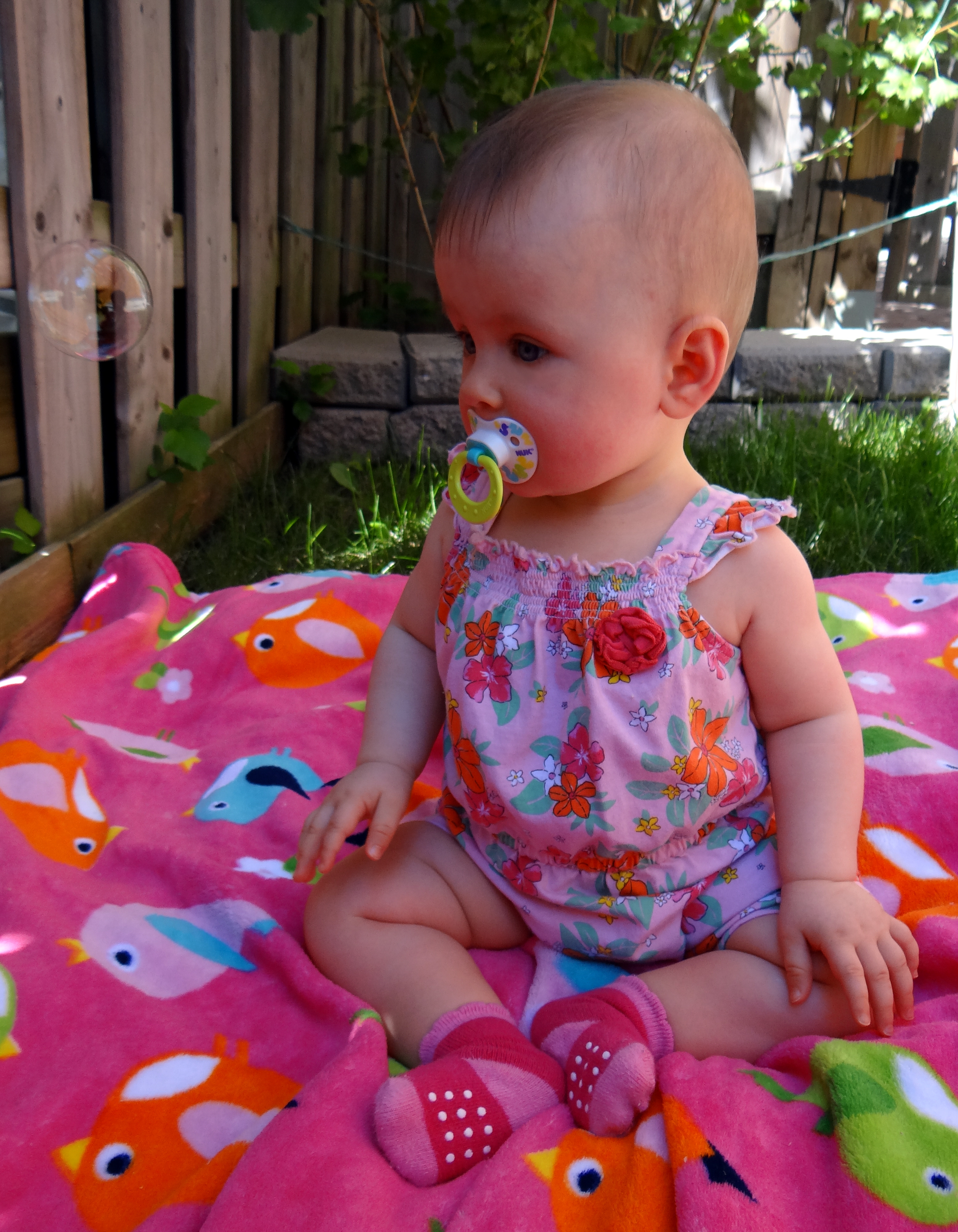 Baby girl having outdoor fun with bubbles