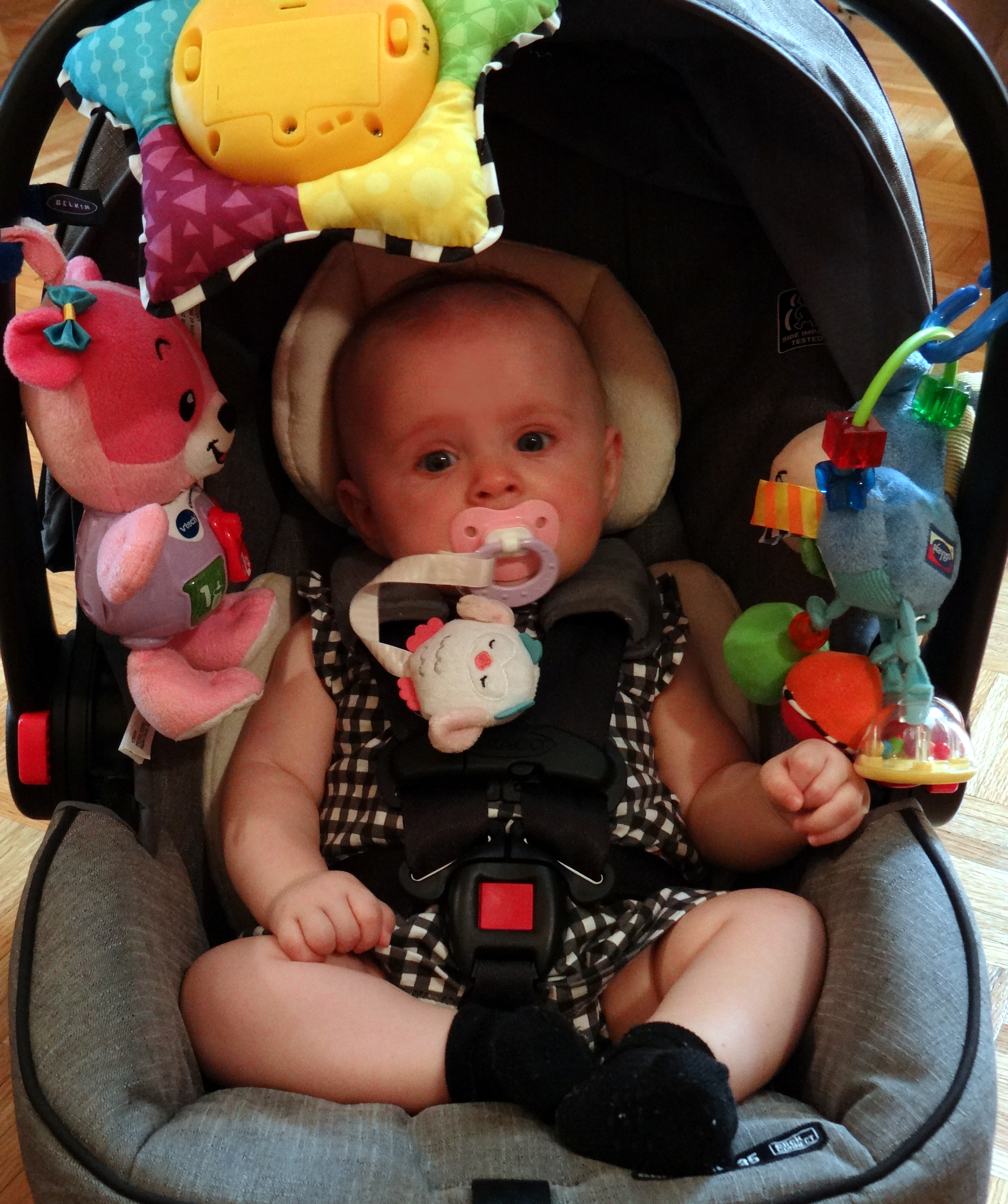 Baby in a car carrier with toys