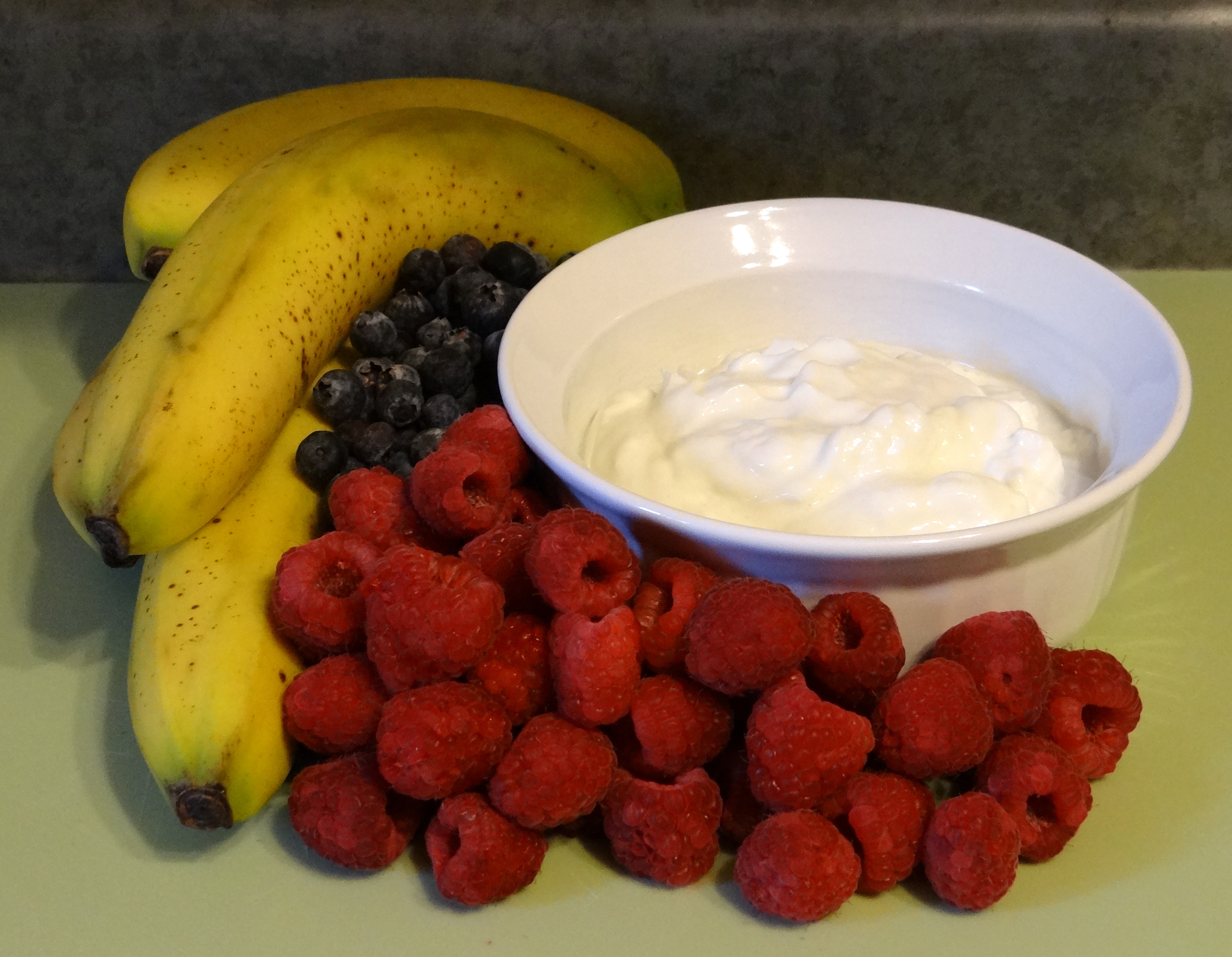Organic banana, raspberry, blueberry, and Greek yogurt
